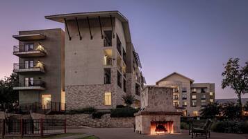 A multi-story building with balconies, a stone facade, and a central courtyard with a fireplace.