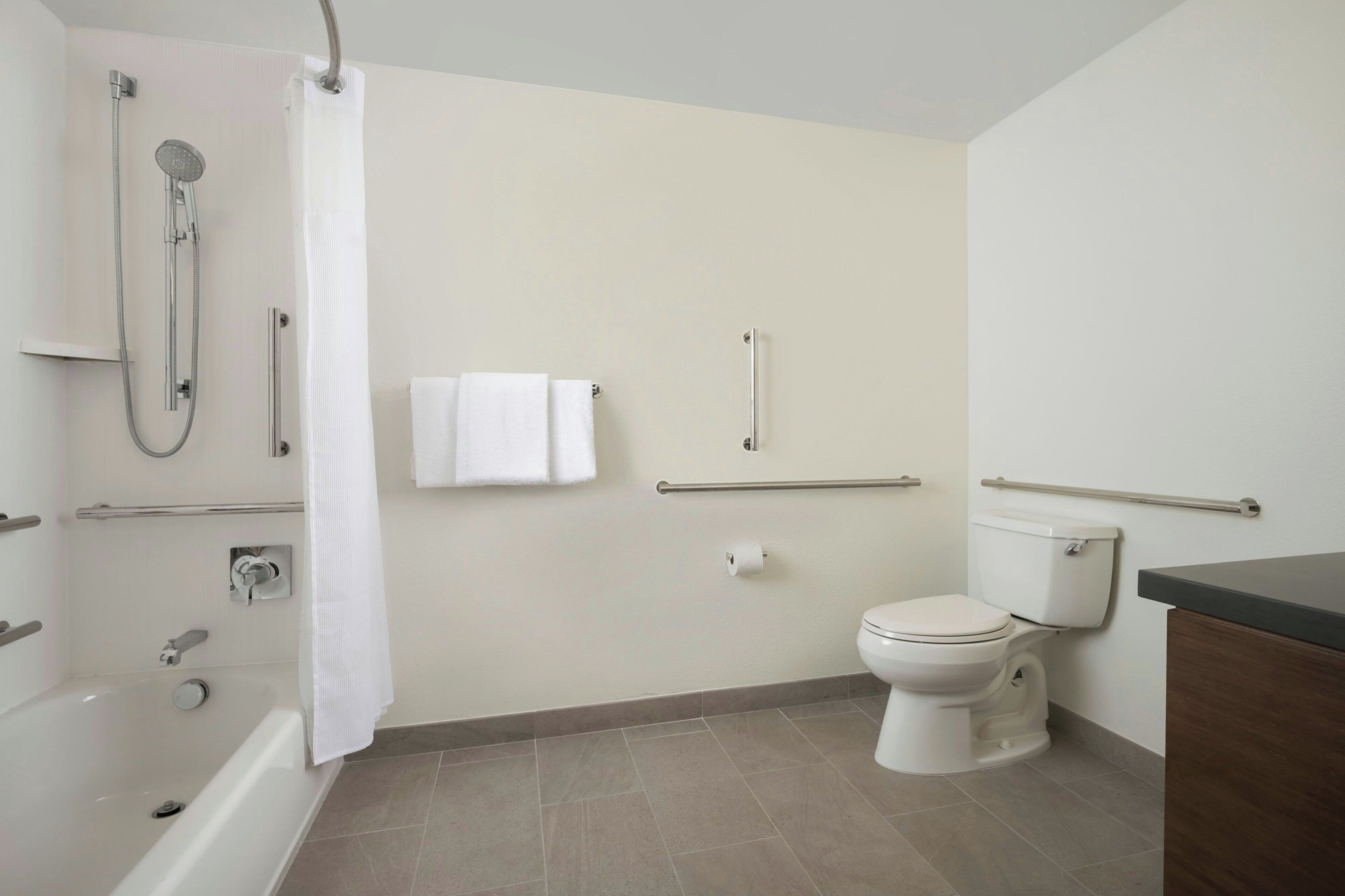 A bathroom with a bathtub, toilet, and shower.