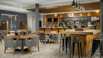 A modern restaurant with a bar area, seating, and a menu board.