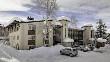 A multi-story building with a flat roof and snow-covered surroundings.