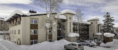A multi-story building with a flat roof and snow-covered surroundings.
