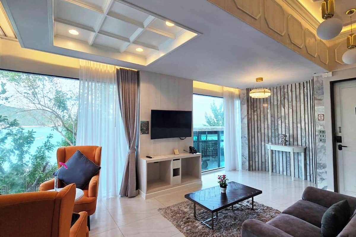 A modern living room with a sofa, a coffee table, and a TV mounted on the wall.