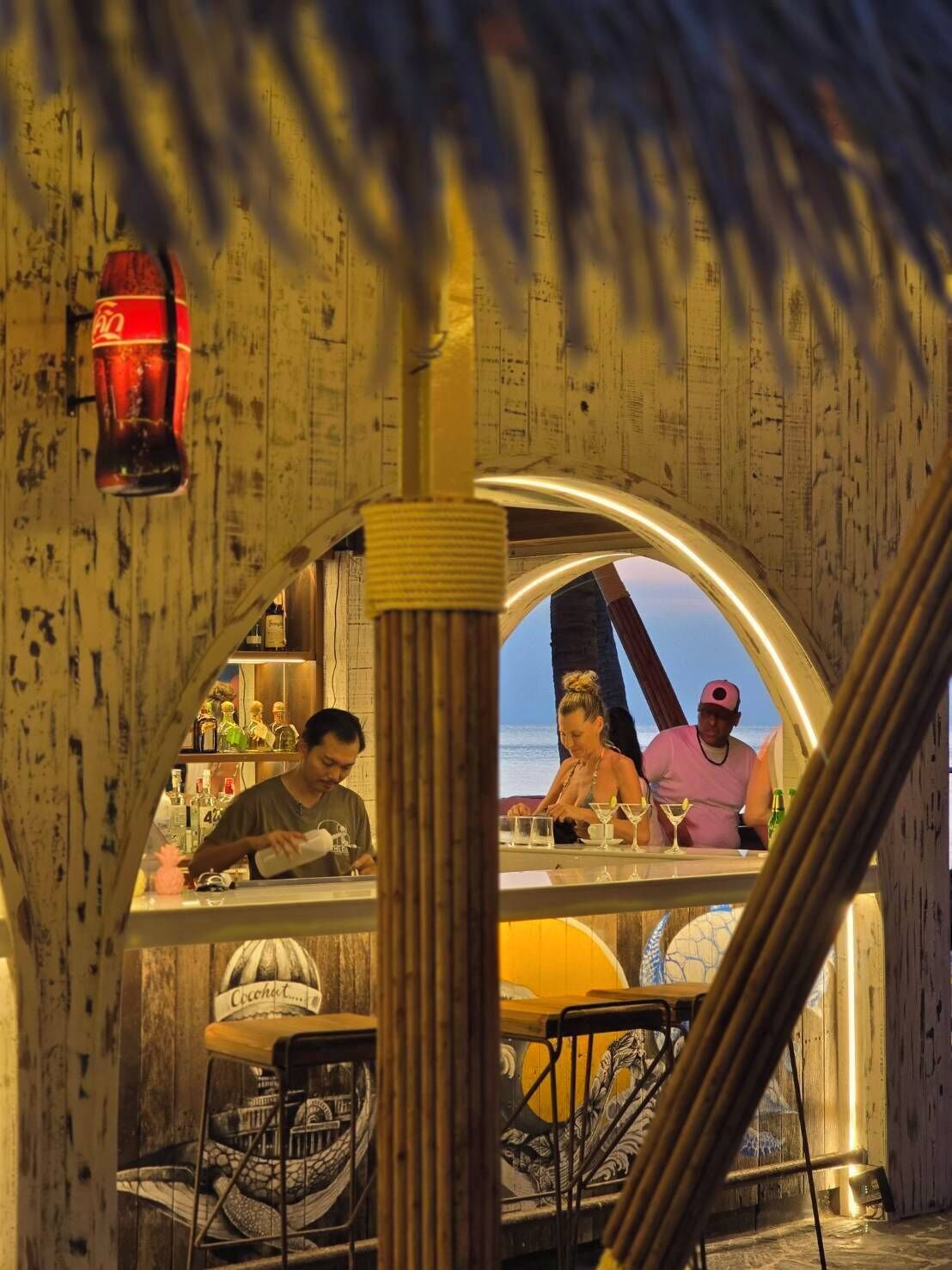 A bar area with wooden walls and a view of the ocean.
