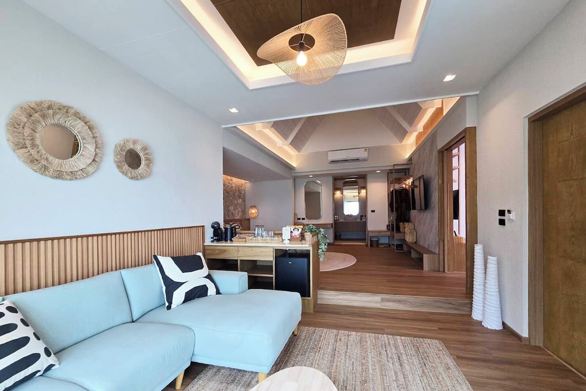 A modern living room with a light blue sofa, a round coffee table, and a ceiling light fixture.
