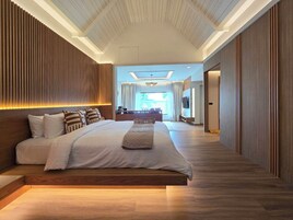 Habitación de hotel moderna con una cama grande, paneles de madera, un televisor de pantalla plana y vistas al exterior.