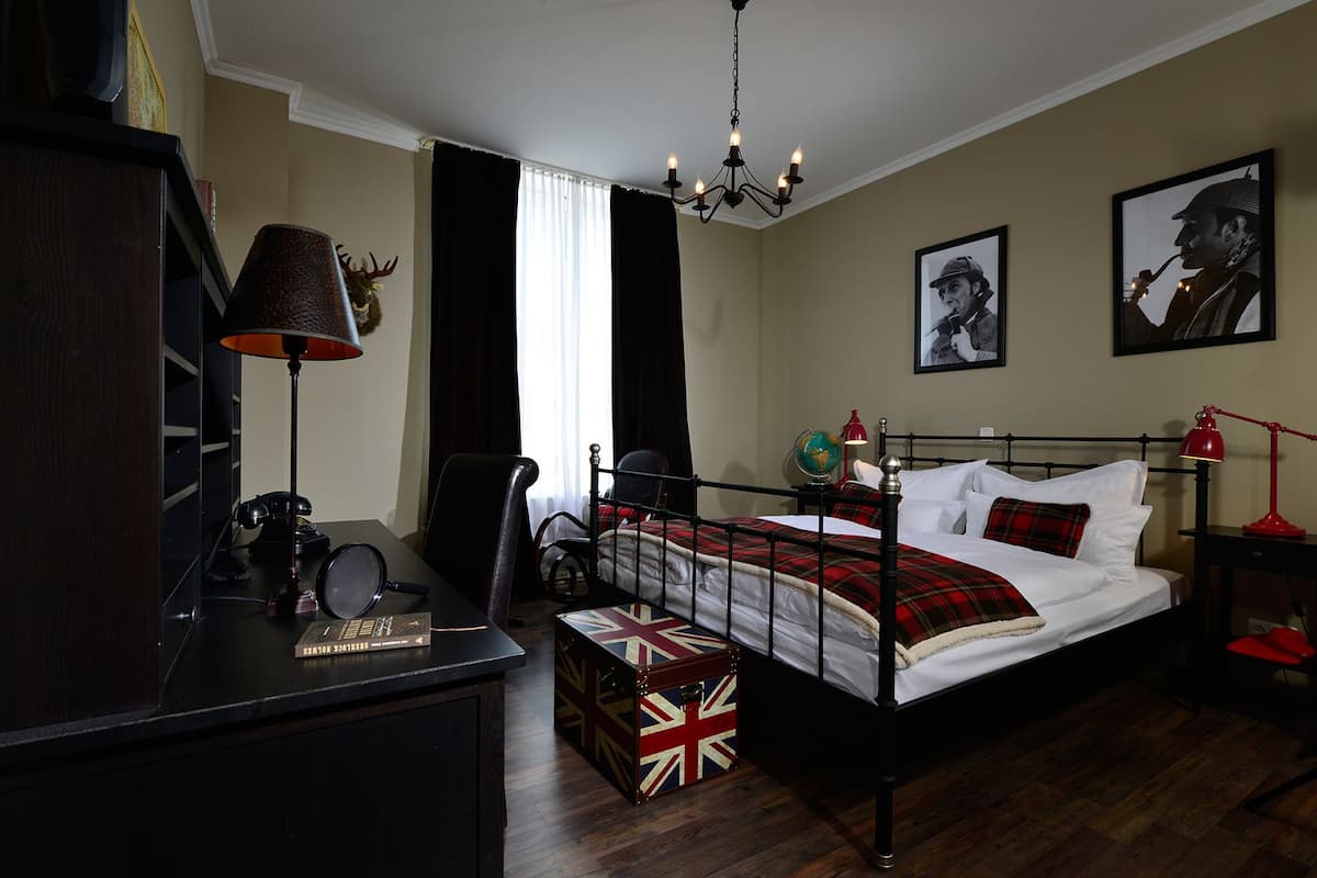 Ein ordentlich eingerichtetes Schlafzimmer mit Bett, Schreibtisch, Globus und Lampe.