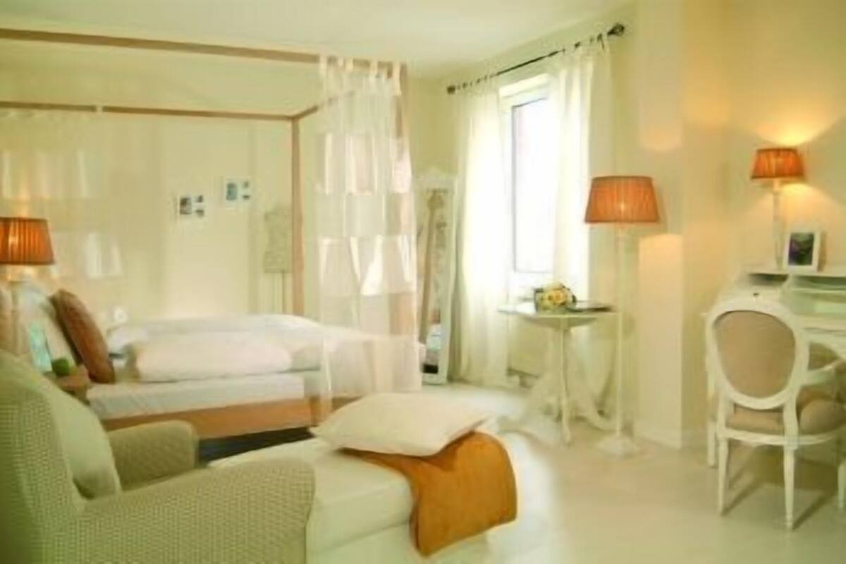Ein Hotelzimmer mit Bett, Schreibtisch, Stuhl und einer Couch.