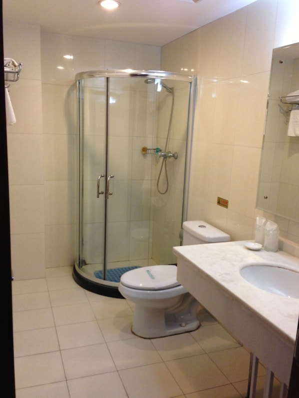 A modern bathroom with a glass-enclosed shower, a white toilet, and a marble sink. - King Parkview Hotel (Beijing)
