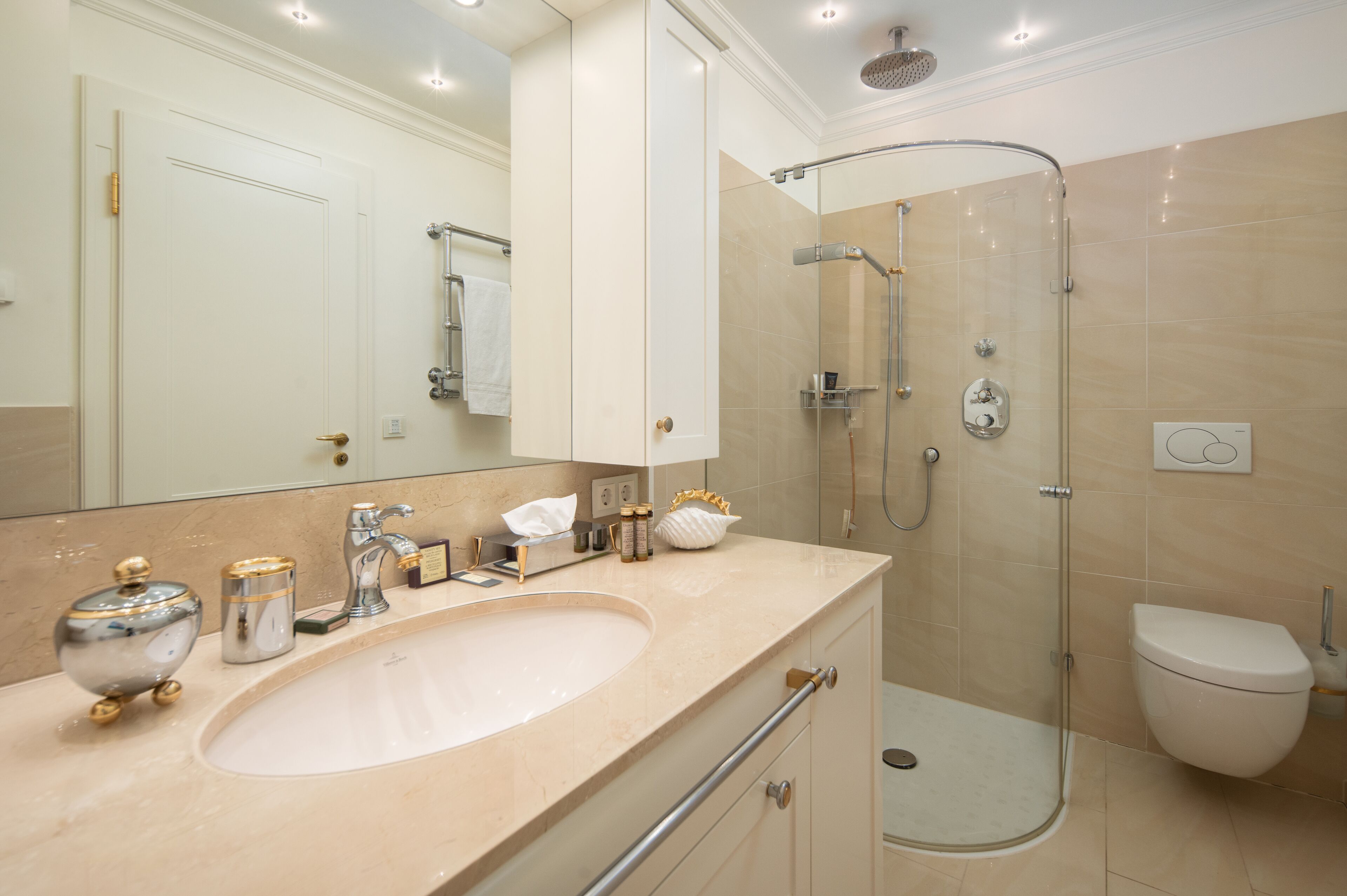 Un baño moderno con un lavamanos grande, una ducha con cerramiento de vidrio y un inodoro.