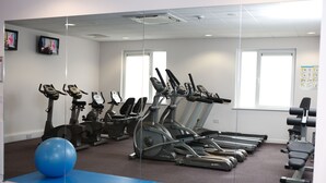 A gym with treadmills, stationary bikes, and exercise balls. - Leonardo Hotel Derby (Derby)