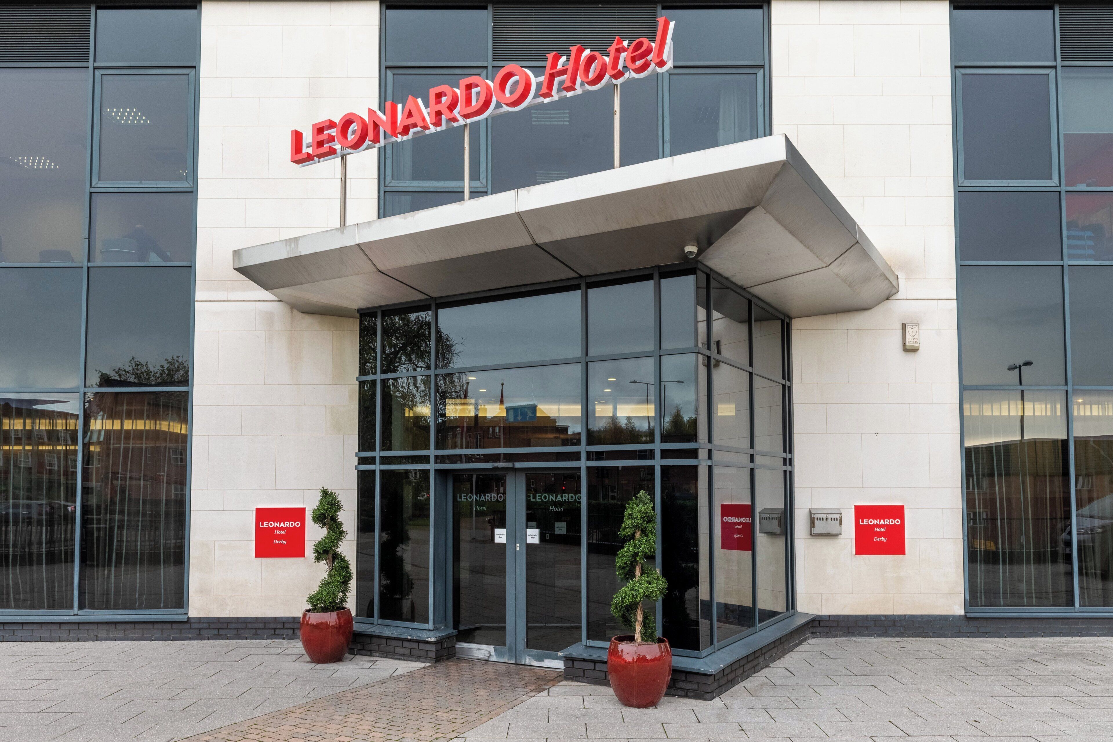 The exterior of the Leonard Hotel with a modern design, featuring large glass windows and a prominent red sign.