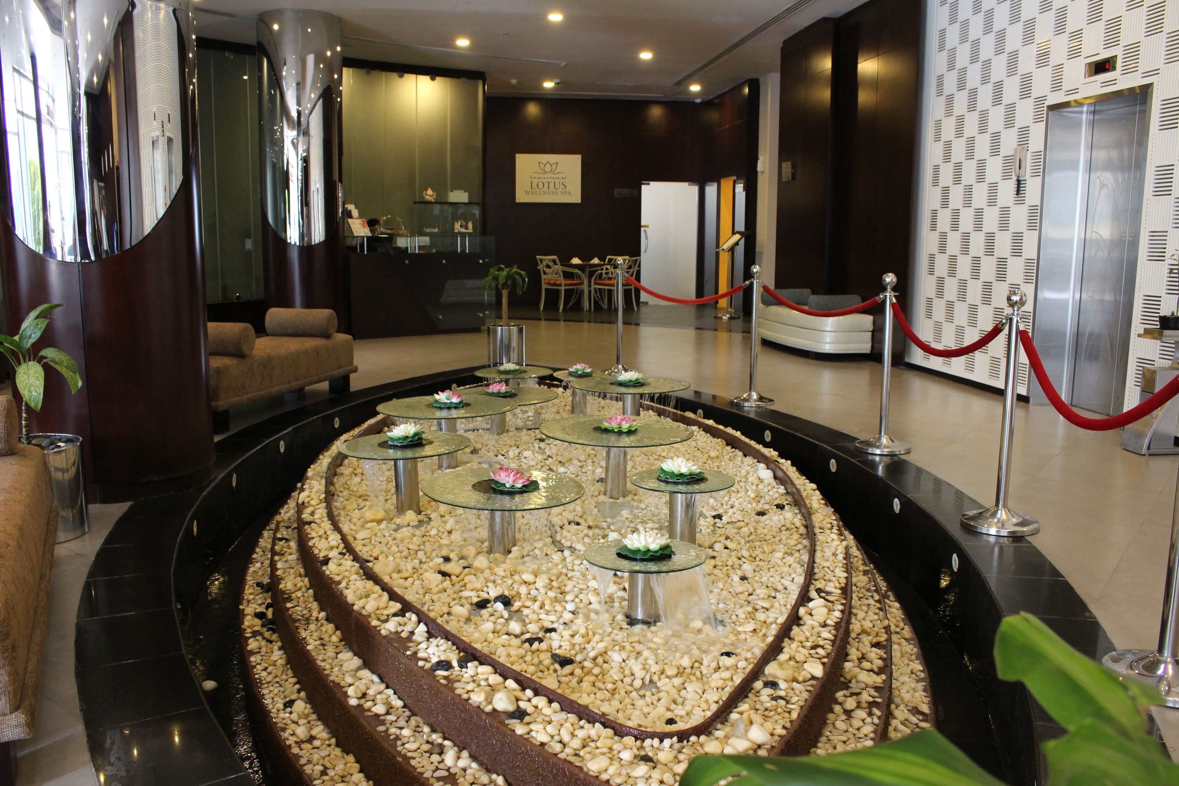 A reception area with a circular water feature, a reception desk, and a seating area.