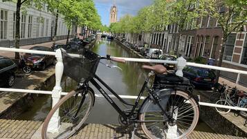 Een fiets geparkeerd op een brug, met een gracht op de achtergrond.
