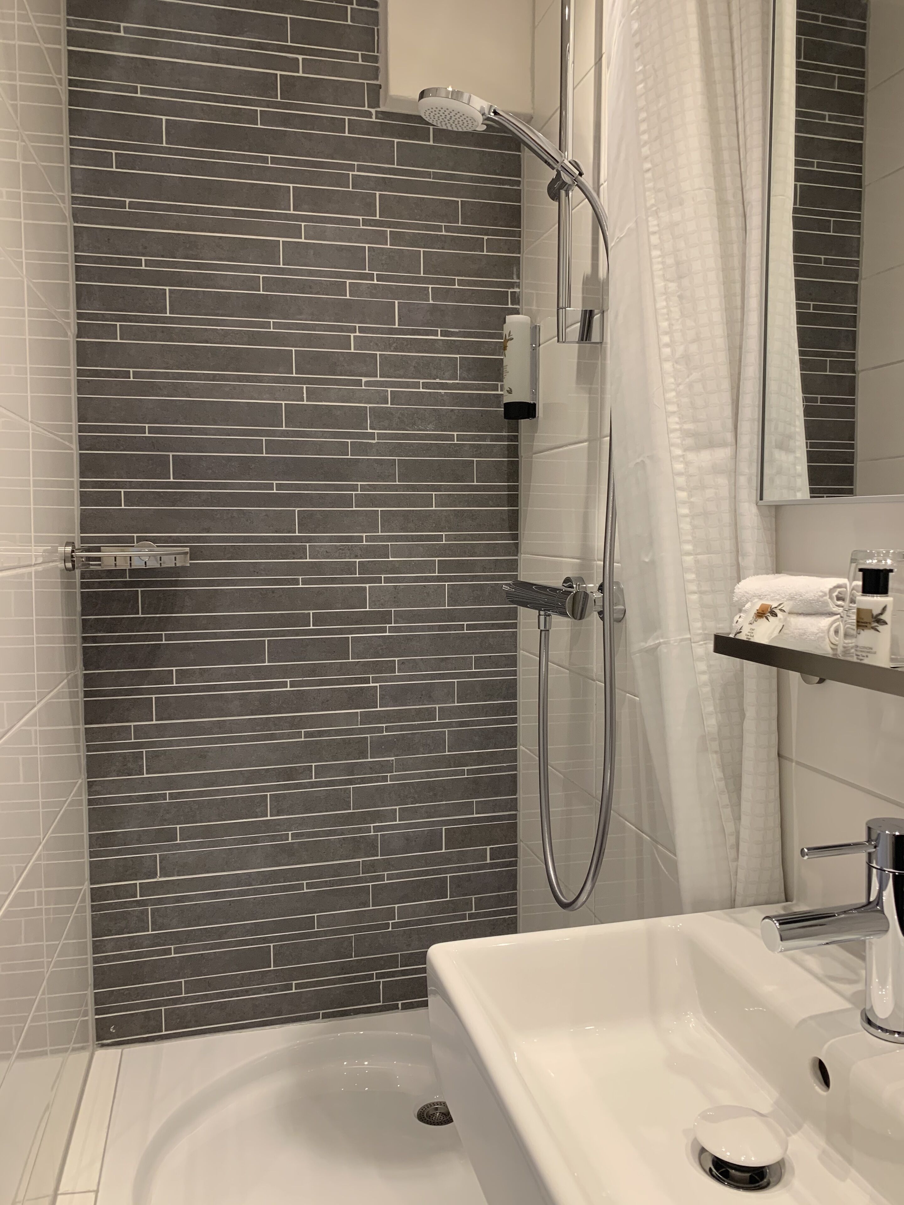 Un bagno moderno con doccia, vasca e un mobile vanità con specchio.