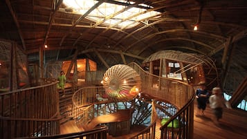 Stunning spiral staircases ascend to different levels within this unique interior space, blending natural materials and airy atmosphere.