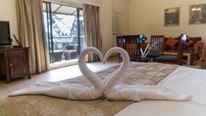 Habitación de hotel con cama, televisión, escritorio y balcón.