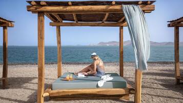 Vlak bij het strand, ligstoelen aan het strand, parasols, strandlakens