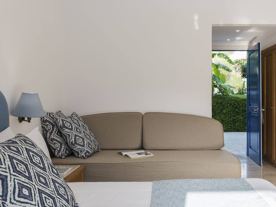 Un dormitorio con cama, sofá y mesita de noche.