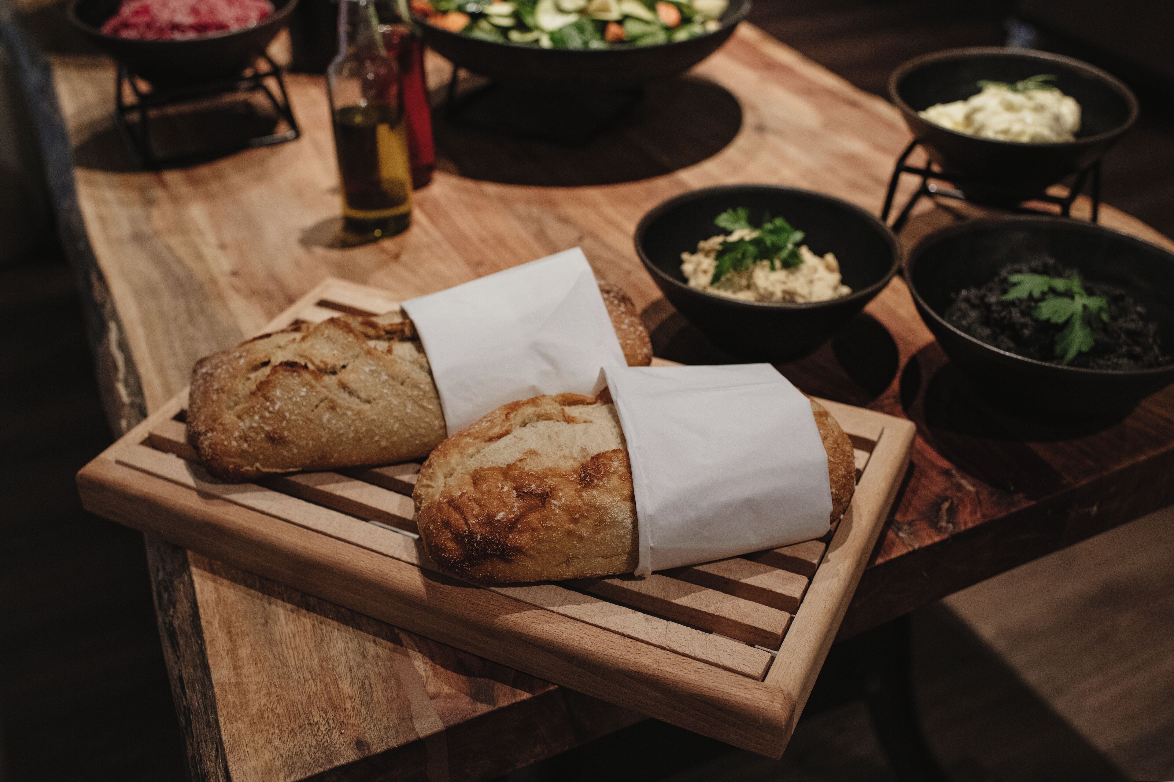 Two loaves of bread on a wooden cutting board.