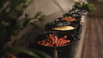 En buffé med ett urval av rätter, inklusive korv, ris och andra färdiglagade maträtter.