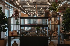 Un interior moderno con conductos a la vista, iluminación de estilo industrial y diversas plantas.