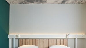 A modern hotel room with two beds, wooden headboards, and a white ceiling with a grid pattern. - ibis Clamart Paris Velizy (Clamart)