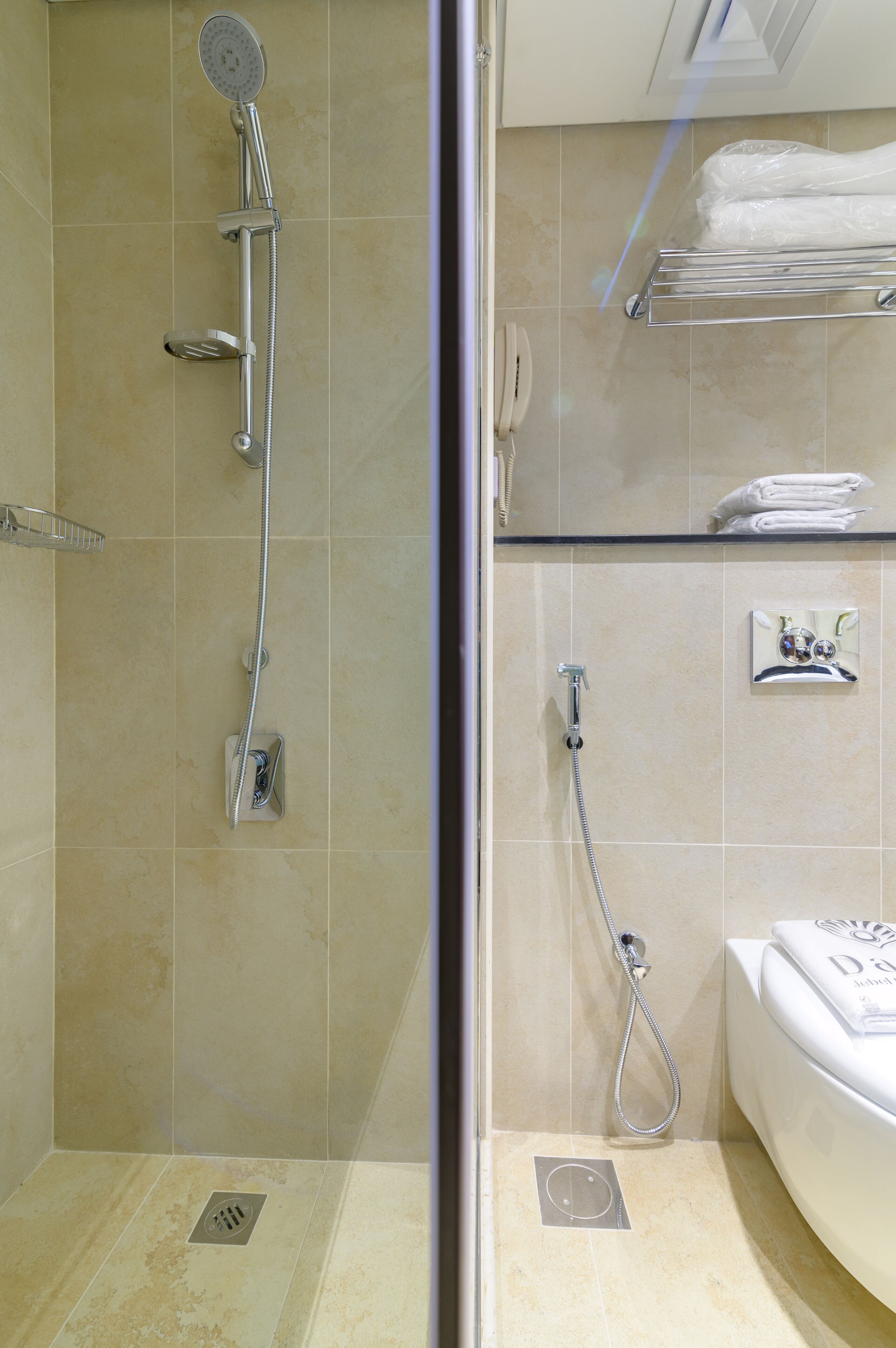 A bathroom with a glass-enclosed shower, a toilet, and a sink.