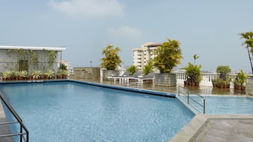 Una piscina al aire libre, tumbonas