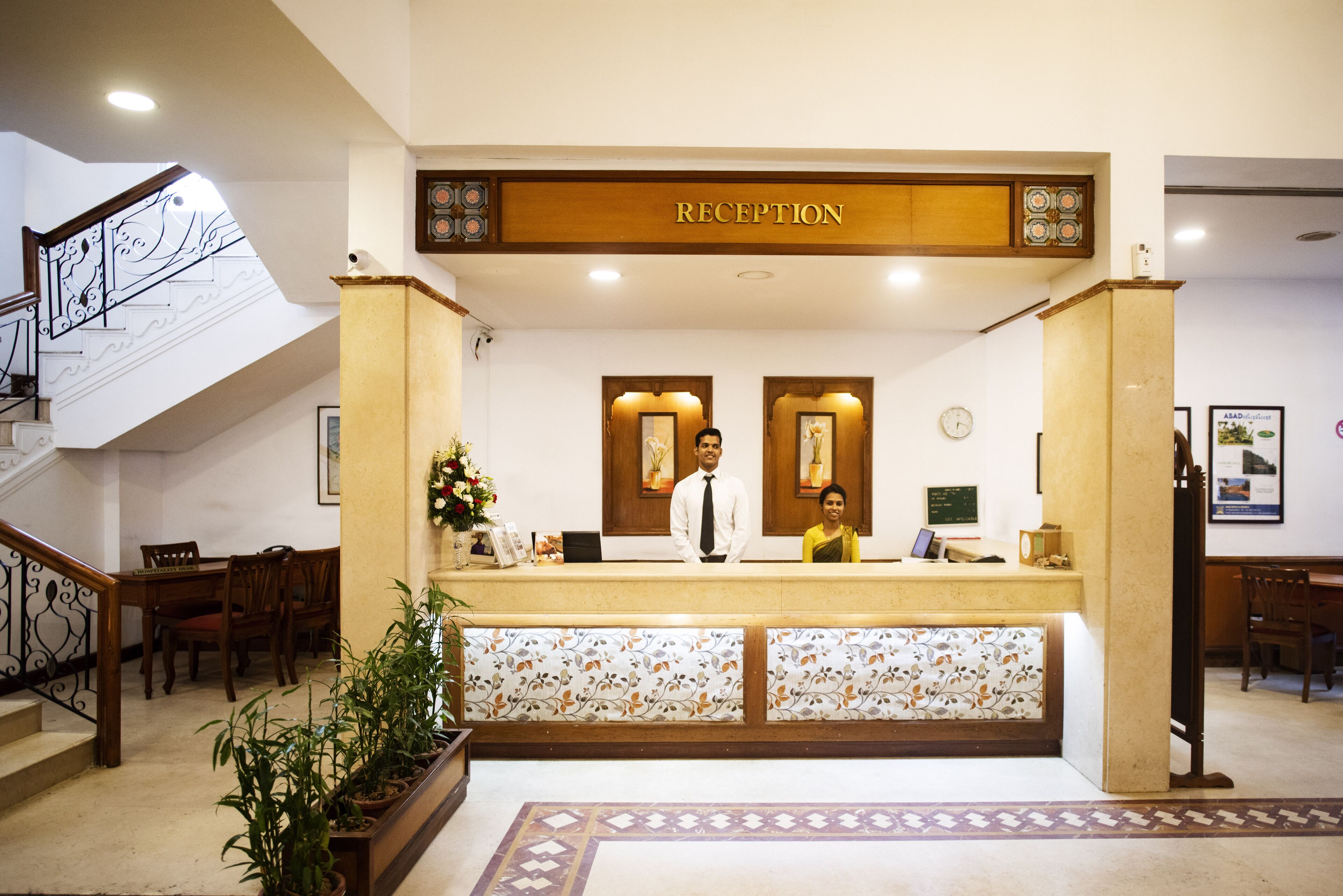 A reception area with a reception desk, a staircase, and a reception sign.