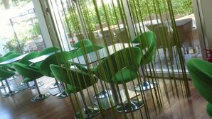 Una habitación con sillas verdes y suelo de madera.