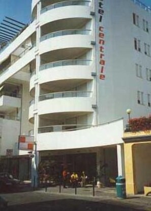 Un hotel a più piani con balconi e un ingresso centrale.