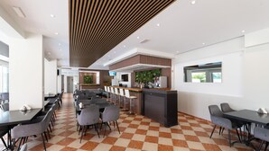 A modern restaurant with checkered flooring, a bar area, and multiple seating arrangements.