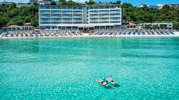 A hotel with multiple floors, a beachside location, and a pool area.