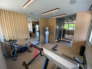 A modern gym with cardio equipment, weight machines, and free weights.