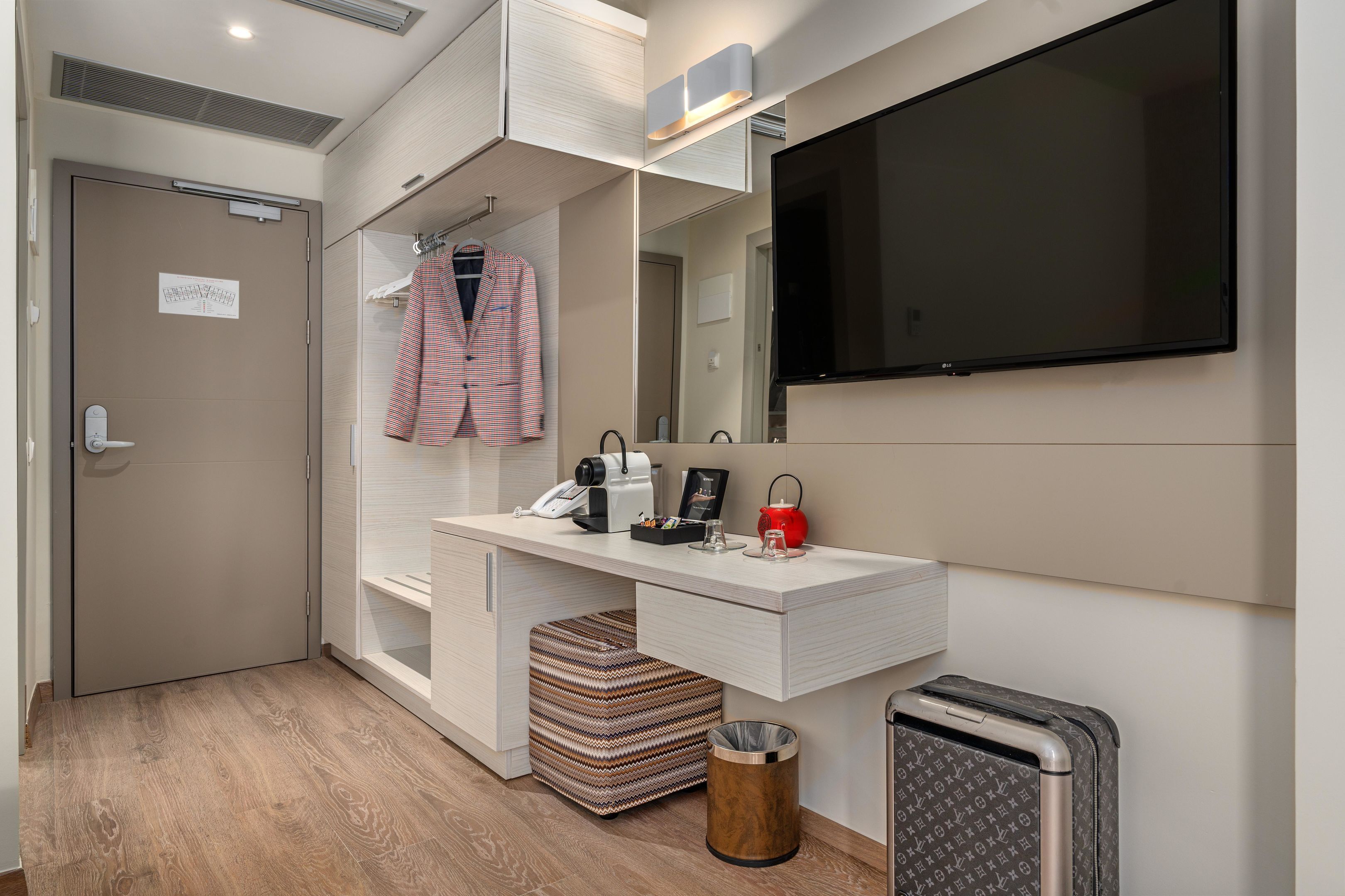 Un baño moderno con tocador, espejo y televisor montado.