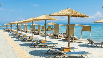 Aan het strand, ligstoelen aan het strand, parasols, strandlakens