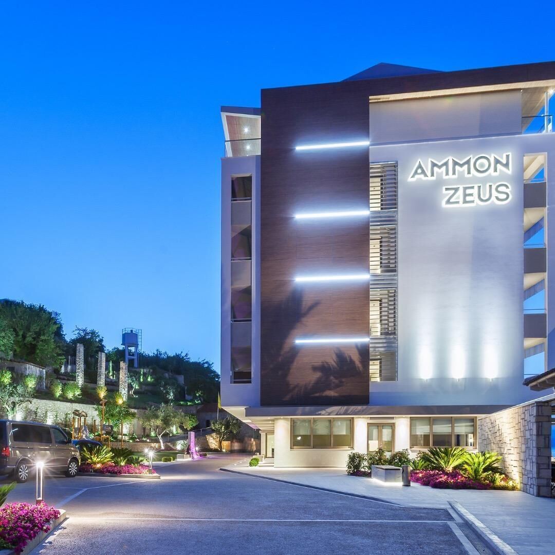 A modern building with a prominent sign reading "AMMON ZEUS".