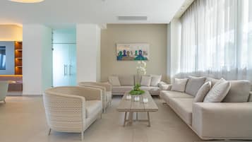 Una sala de estar moderna con un conjunto de sofás, una mesa de centro y un cuadro en la pared.