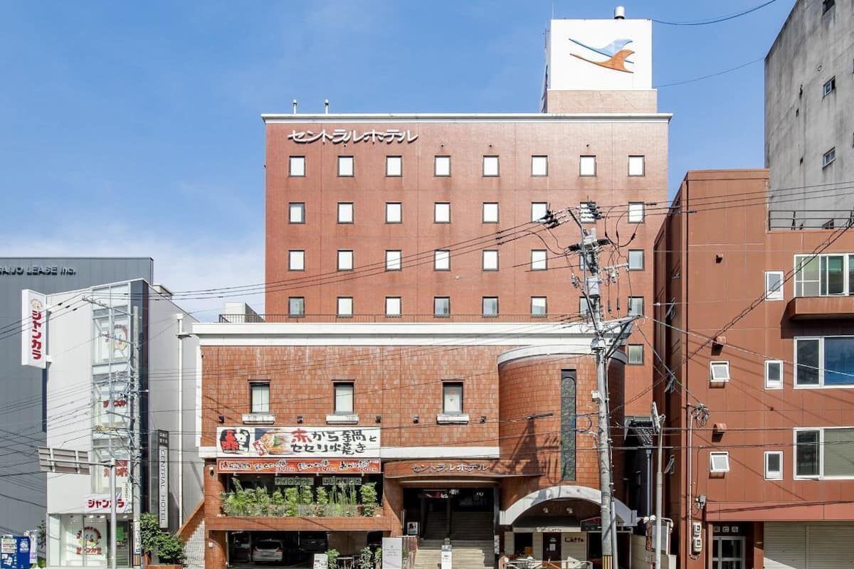 A hotel with a red brick facade, multiple windows, and a sign indicating it is a hotel.