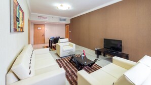 Una sala de estar moderna con sofás blancos, un televisor de pantalla plana y una mesa de centro.
