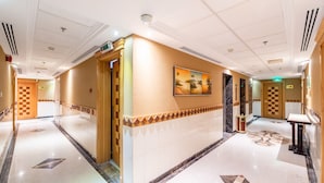 Un hall de hotel con un suelo de diseño a cuadros, una recepción y un cuadro colgado en la pared.
