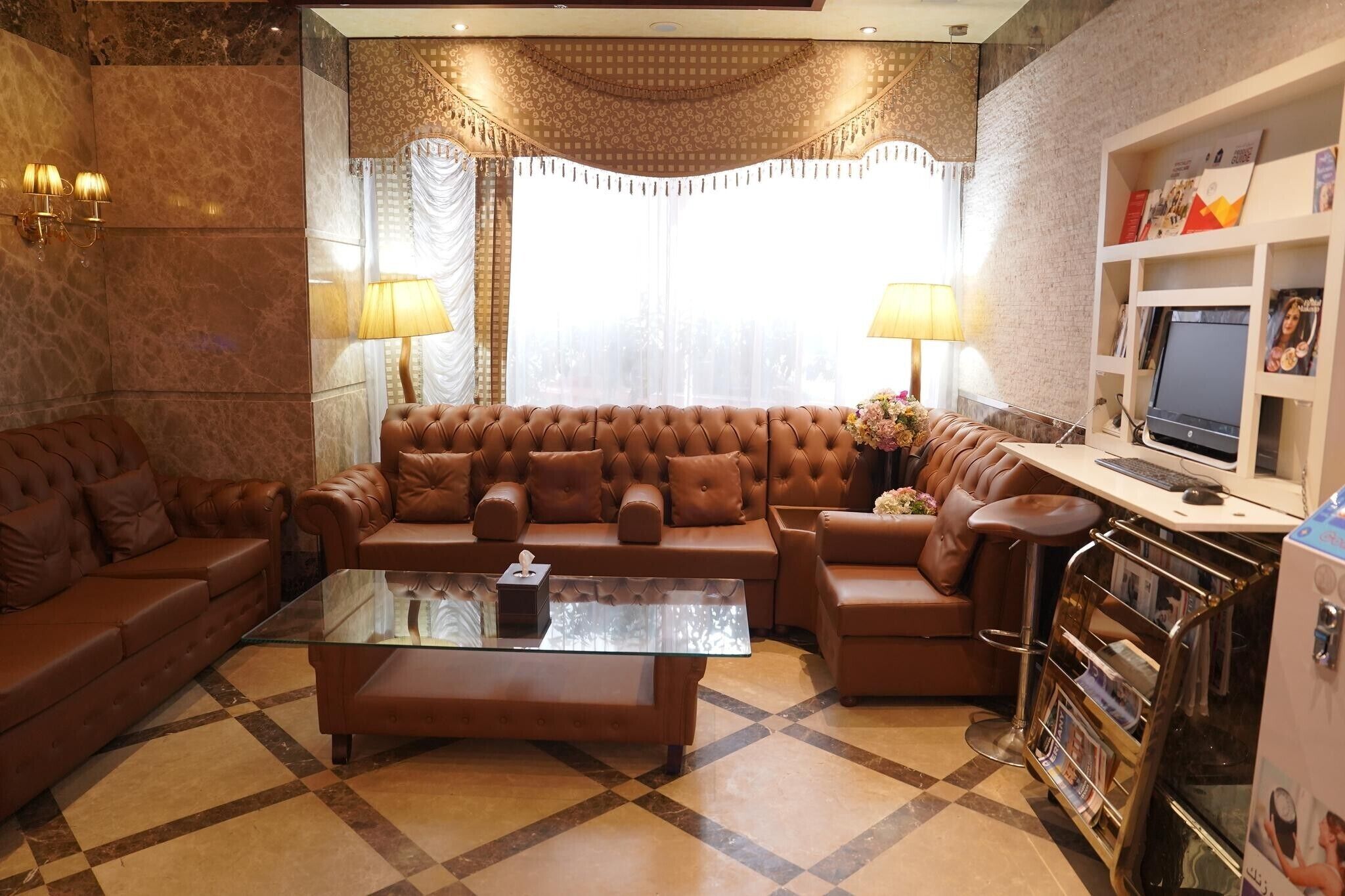 A living room with a brown leather sectional sofa, a glass coffee table, and a TV on a white stand.