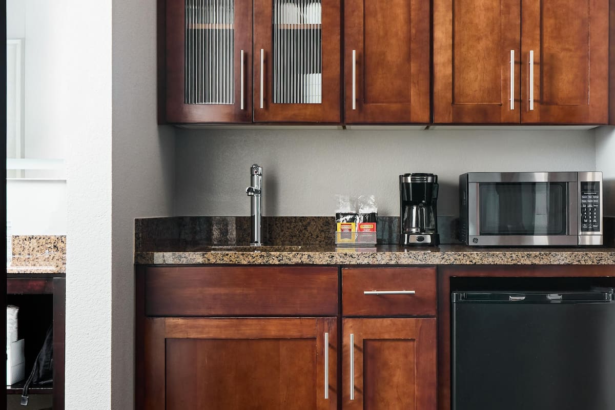 Microwave, coffee/tea maker, cleaning supplies, freezer