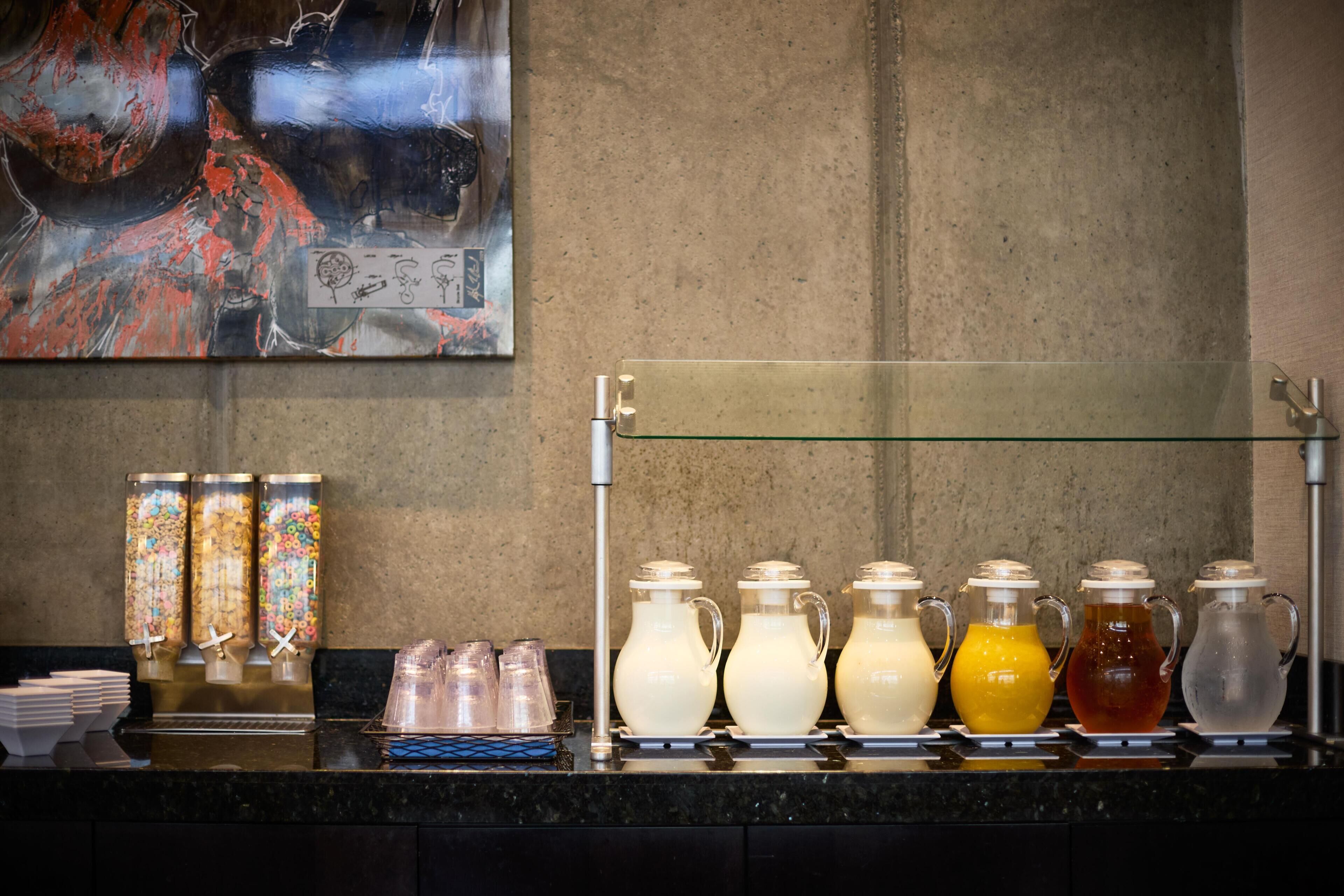 A beverage station with various drink dispensers and containers.