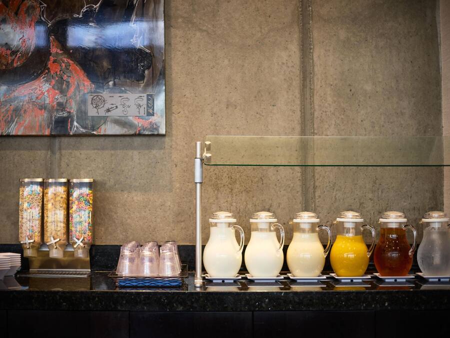 A beverage station with various drink dispensers and containers.