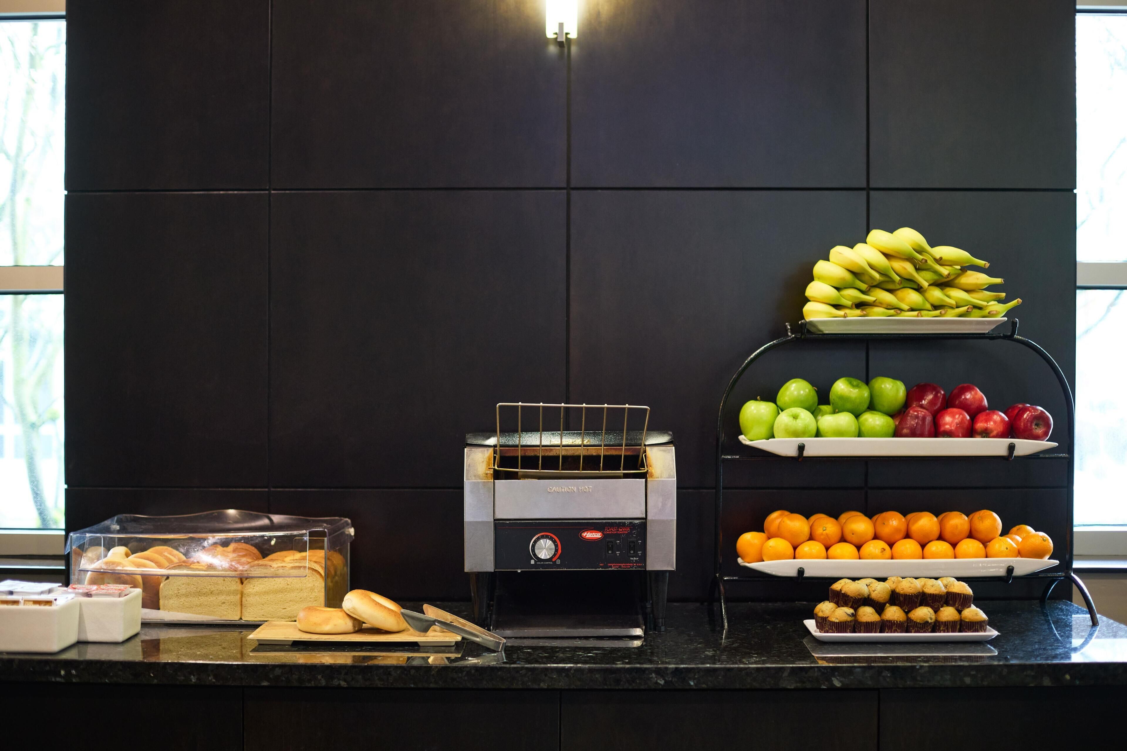 Un buffet proposant une variété de plats, notamment des fruits, des pâtisseries et un coin grillade où les aliments sont préparés à la demande.