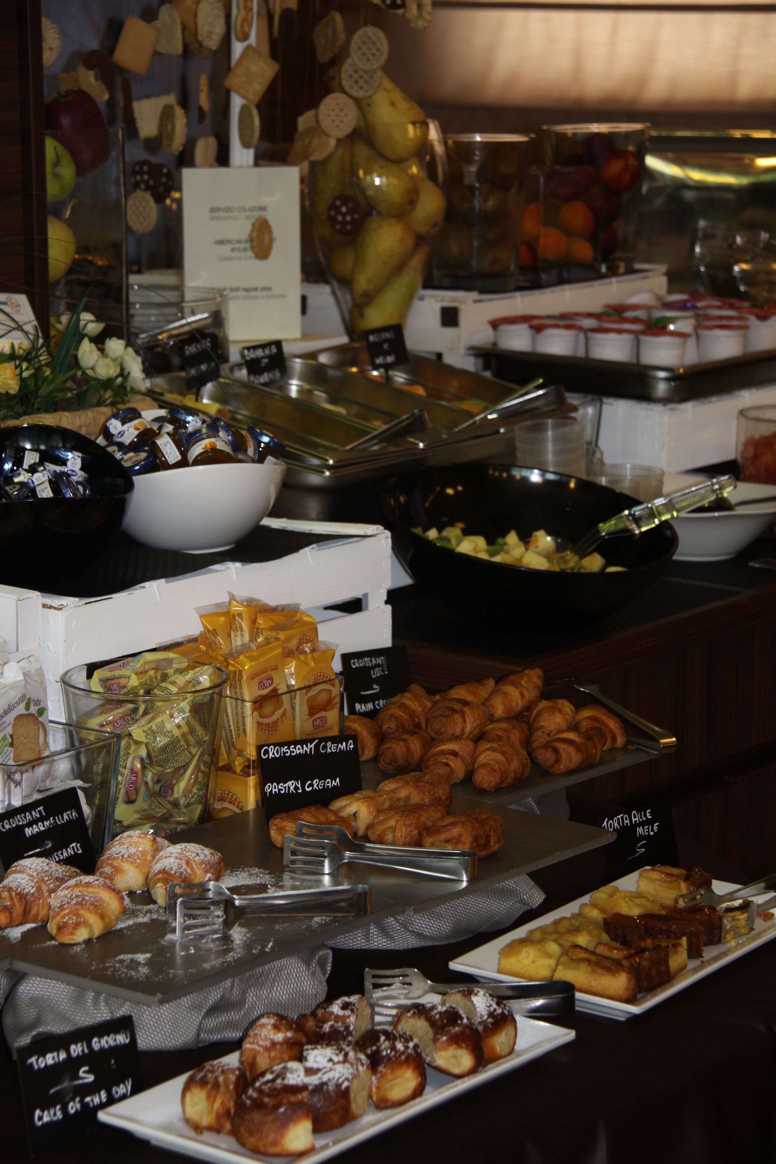 Un buffet con diverse pietanze tra cui pasticcini, frutta e salse.