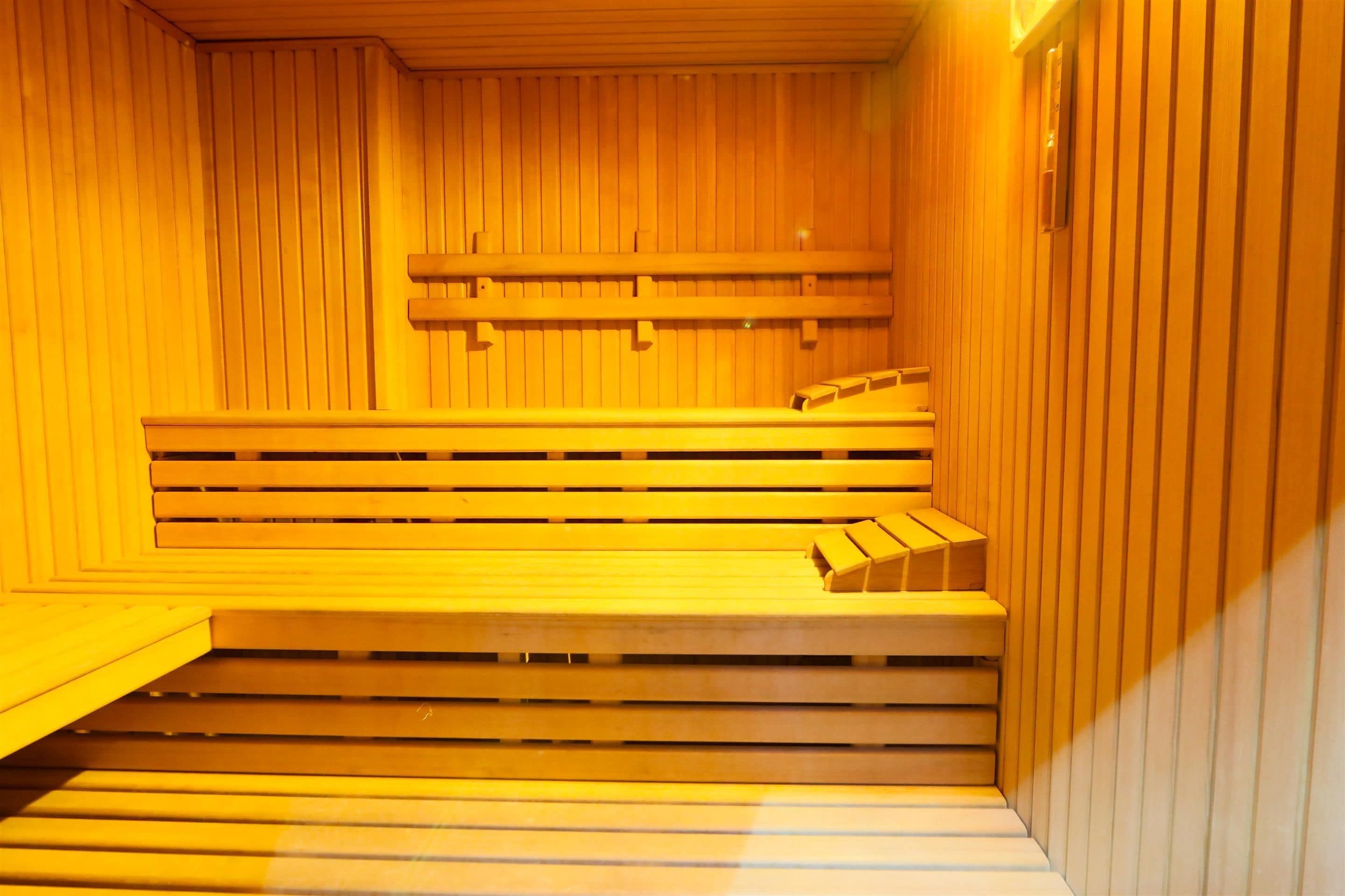 Una sauna con bancos de madera y un suelo inclinado que conduce a una plataforma elevada.