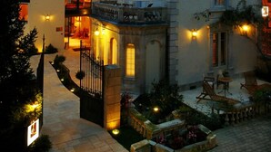 Un edificio grande e histórico con varios pisos, una torre destacada y una entrada bien iluminada.