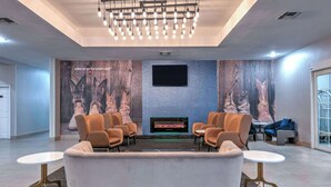 A modern lounge area with a fireplace, comfortable seating, and a flat-screen TV.